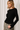 Model wearing black Boat Neck Semi Bell Long Sleeve Knit Top with patterned pants