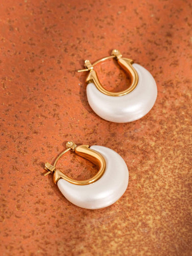 Roselle 18K Gold Non-Tarnish Teardrop Hoop Earrings displayed on a textured orange background.