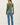 Back view of model wearing green Ultra Soft Basic Button Up Cardigan with blue jeans