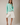 Model wearing mint green Round Rolled Hemline Detail Thin Sweater Cardigan with white shorts