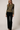 Full-length view of model wearing olive green Boat Neck Semi Bell Long Sleeve Knit Top with black pants