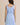 Light blue boat neck sleeveless side tie mini dress worn by a model, back view.