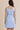 Light blue boat neck sleeveless side tie mini dress worn by a model, back view.