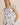 ROUND NECK RUFFLE SHORT SLEEVE FLORAL PRINT DRESS modeled by a smiling woman with a floral pattern.