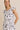 ROUND NECK RUFFLE SHORT SLEEVE FLORAL PRINT DRESS modeled by a smiling woman with a floral pattern.