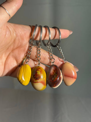 Mookaite Jasper Crystal Keychain featuring polished yellow, orange, and brown gemstones displayed in a hand