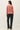 Back view of model wearing pink long sleeve top with black pants