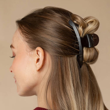 Large Arched Clip Black securely holding thick hair in a stylish updo, featuring an eco-friendly design.