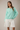 Model wearing mint green Round Rolled Hemline Detail Thin Sweater Cardigan with white pants