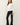 Side view of model wearing white long sleeve top with black pants