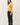 Side view of model wearing yellow button-up cardigan with black pants