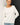Close-up of cream slub pullover sweater fabric and raglan sleeve detail