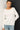 Close-up of cream slub pullover sweater fabric and raglan sleeve detail