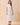 Model wearing a Classic Shirt Collar Neck Pleated Detail Dress in white, featuring a relaxed fit and pleated panel detailing.