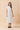 Model wearing a Classic Shirt Collar Neck Pleated Detail Dress in white, featuring a relaxed fit and pleated panel detailing.