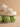 The Polly Cream Ruffle Strap Raffia Platform Slide Sandal placed on a net with green apples, showcasing its stylish design.