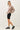 Side view of model wearing stone cotton modal fleece sweatshirt with black shorts