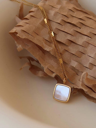 Felicity 18K Gold Non-Tarnish Shell Square Necklace on a textured background
