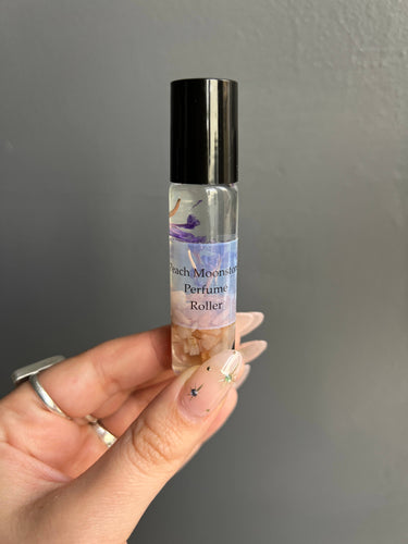 Peach Moonstone Crystal Perfume Roller in a hand, displaying its unique packaging and essential oils.