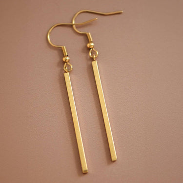 18K Gold Plated Waterproof Stainless Steel Drop Earrings 6976 displayed as a pair on a brown background