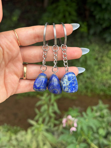 Lapis Lazuli Crystal Keychain featuring polished blue gemstones held in a hand outdoors