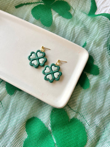 Two Tone Shamrock Earrings Clover Clay Earrings displayed on a tray with green fabric in the background.