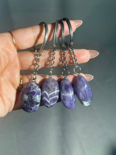 Chevron Amethyst Crystal Keychain featuring polished purple and white patterned gemstones displayed in a hand