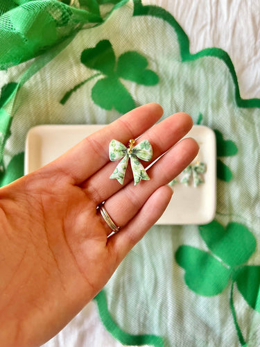Clover Bow Earrings Shamrock Bow Earrings Lucky Bow in a hand, featuring green polymer clay design.