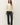 Full-length view of model wearing cream raglan sleeve pullover sweater with black pants