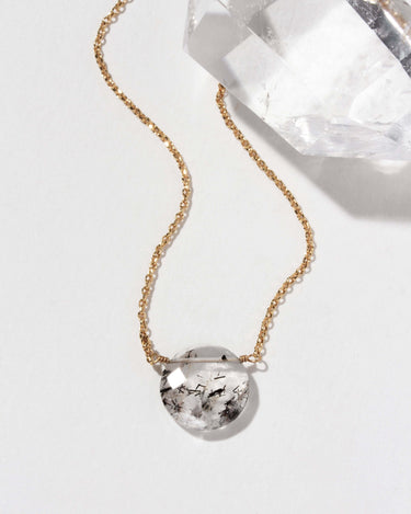 Gem in the Moon Gemstone Necklace- Tourmalinated Quartz featuring a round gemstone on a gold chain.