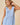 V-neck Baby doll Sleeveless Blouse with Ruffle Top in light blue, featuring ruffle detailing and button front closure.