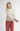Front view of model wearing Irisha oatmeal diamond pointelle sweater with red pants