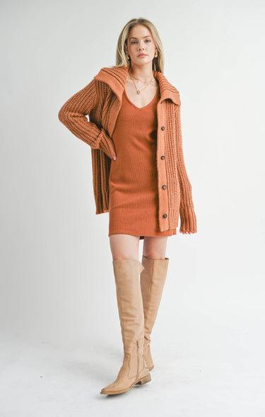 Front view of model wearing Elianna rust wide collar cardigan with white shorts
