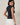 HIGH NECK EXTENDED SHOULDER SIDE RUCHED POLKA DOT TOP worn by a model from the back, showcasing the stylish design and polka dot pattern.