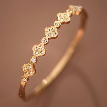 18K Gold PVD Plated Waterproof Stainless Steel Bangle displayed diagonally on a brown background