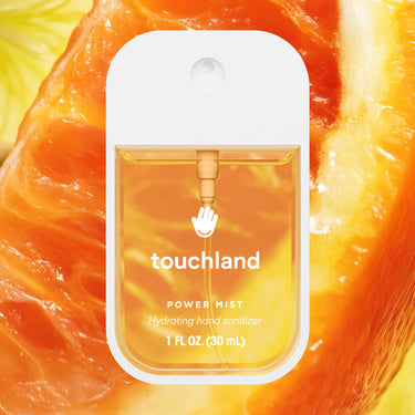 Citrus Grove Power Mist Hydrating Hand Sanitizer bottle with citrus background