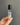 A hand holding a Mother Of Pearl Crystal Perfume Roller, featuring floral and pearl designs in a clear roller bottle.