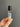 A hand holding a Mother Of Pearl Crystal Perfume Roller, featuring floral and pearl designs in a clear roller bottle.