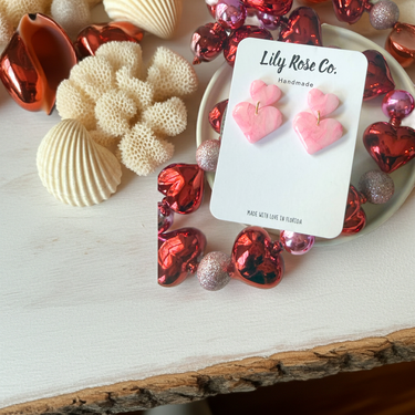 Pink Marble Heart Earrings displayed with decorative accessories on a neutral background