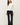 Front view of model wearing white long sleeve top with black pants