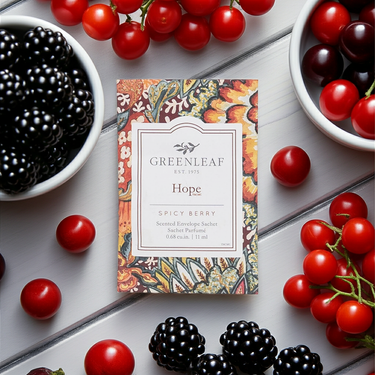 Hope Small Sachet Fragrance by Greenleaf surrounded by fresh berries on a wooden surface.