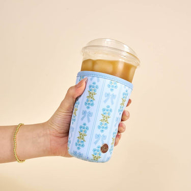 Sip Savvy Drink Sleeve Large Oh So Fancy Blue holding an iced drink, featuring a floral design and snug fit for comfortable use.
