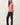 Side view of model wearing pink long sleeve top with black pants