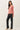 Side view of model wearing pink long sleeve top with black pants