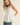 Pleated throughout Sleeveless A Line Top displayed on model, featuring pleating and back keyhole closure.