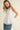 Pleated throughout Sleeveless A Line Top displayed on model, featuring pleating and back keyhole closure.