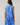 Model wearing the Kaidy Tropical Loly Trapeze Mini Dress in blue, showing the back and ruffle detail.
