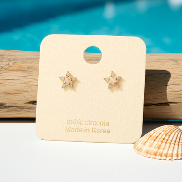 Gold Dipped Cz Cluster Star Stud Earrings displayed on card with cubic zirconia, made in Korea, against a blue background.