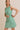 BOAT NECK SLEEVELESS SIDE TIES MINI DRESS model wearing size small in green striped fabric