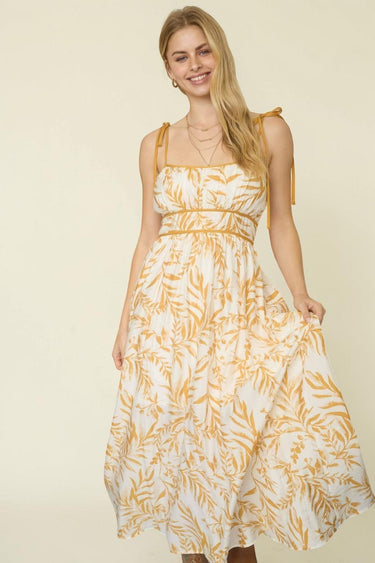 LEAF PRINT SPAGHETTI TIE STRAP MIDI DRESS featuring adjustable straps and A-line silhouette.